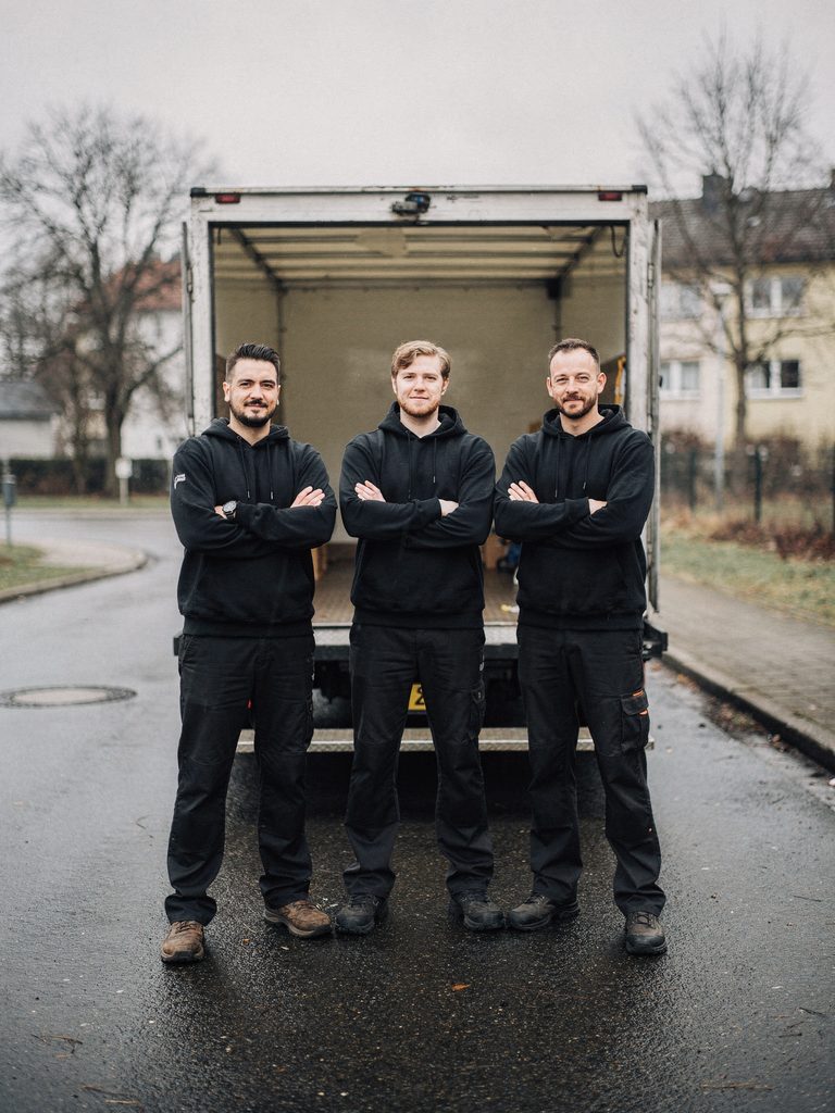 Das Team von Kottke-Umzüge steht mit verschränkten Armen vor dem Umzugs-LKW