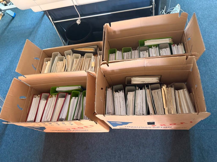 Vier offene Kottke-Umzüge Kartons mit Aktenordnern stehen bei einem Büroumzug vor dem Bürofenster